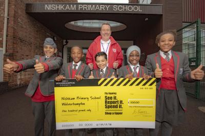 Kevin Finch, site manager pictured with the giant cheque and year 5 and 6 students at Nishkam Primary School Wolverhampton