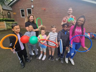 Fran Oliver, Activity Co-ordinator at New Park Village Activities Network, and Councillor Chris Burden, Cabinet Member for Children, Young People and Education, with young people enjoying some of the Yo! Wolves summer activities