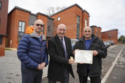 West Midlands Police Force Design Out Crime & Crime Reduction Manager, Mark Silvester (left), and Designing Out Crime Officer Birmingham Partnerships, West Midlands Police, Tarkan Mehmet-Ali (right), present Council Deputy Leader and Cabinet Member for City Housing, Cllr Steve Evans (centre), with the Secured by Design Gold certificate for the new Heath Town homes