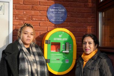 East Park Councillor Lovinyer Daley and Councillor Jasbir Jaspal, the City of Wolverhampton Council's Cabinet Member for Adults and Wellbeing, with the defibrillator which has been installed at East Park Library in memory of Lauren Smith, who tragically passed away last year aged just 29