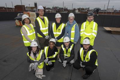 (L-R): On the new City Learning Quarter college campus roof are (back row) - Jas Dolphin, Ministry of Housing, Communities & Local Government, Cllr Chris Burden, City of Wolverhampton Council Cabinet Member for City Development, Jobs and Skills, Louise Fall, City of Wolverhampton College Principal and Chief Executive, Sian Fletcher, Adult Education Wolverhampton Curriculum Manager – Continuing Education and Marketing and Shane Greer, McLaughlin & Harvey Senior Project Manager. (front row) – City of Wolverhampton College students Aleksandra Jaskiewicz (aged 18), Rachel Obo (19), Thomas Law (16) and Fahad Alzafery (18)