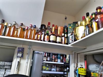 Some of the alcohol on shelving at Super Mahan during the seizures in June 2023 and of the seized alcohol in storage